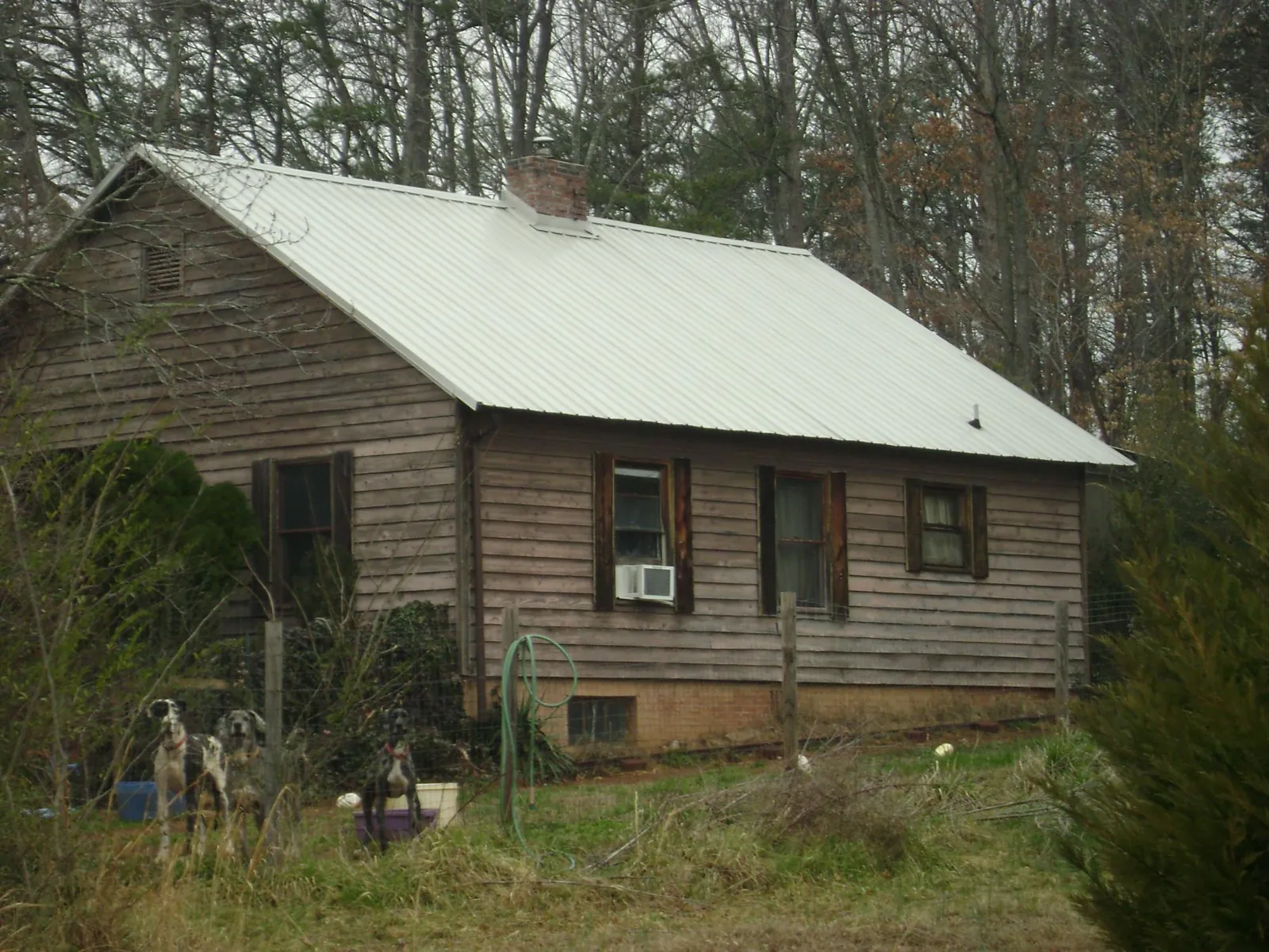 White metal roof on an old wood sided farmhouse, from a Metal Roof Installation job in Austell